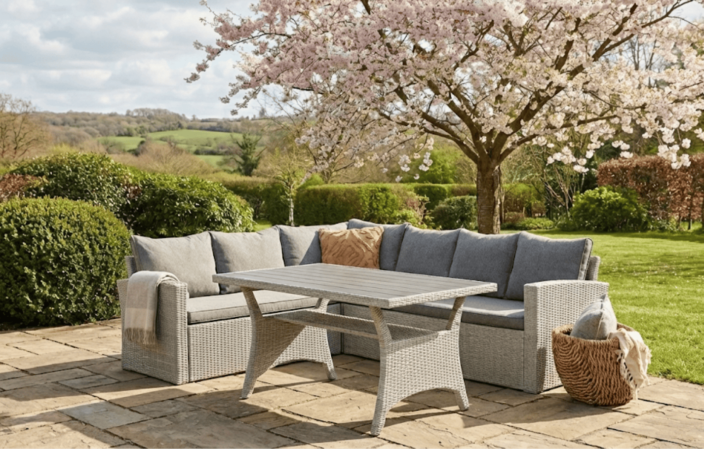 Stockholm 6 Seater Grey Rattan Garden Corner Sofa Set with cover in a British garden